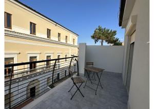 two chairs on the balcony of a building at Villino Tokupellon Apartments in Cupello