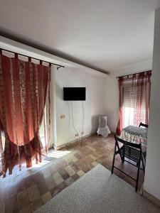 a living room with a bed and a tv and windows at Villino Tokupellon Apartments in Cupello