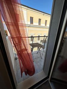 d'une fenêtre donnant sur une terrasse avec une table et des chaises. dans l'établissement Villino Tokupellon Apartments, à Cupello