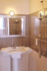 W łazience znajduje się umywalka i lustro. w obiekcie HOTEL RESTAURANT CORTIE w mieście Thuir