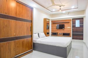 a small bedroom with a bed and a tv at FabHotel Classic Square in Pune