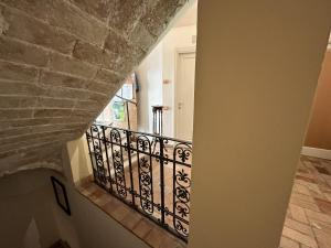 un escalier avec un mur en pierre et une rampe en fer forgé dans l'établissement Villino Tokupellon Apartments, à Cupello