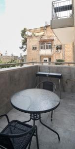 una mesa y sillas en un balcón con un edificio en Hapalmah One, Dira 3, Jerusalem, en Jerusalén