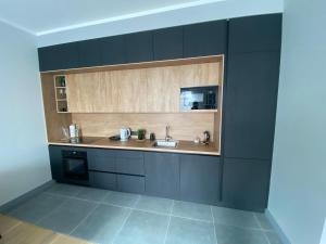 a kitchen with black cabinets and a sink at The SiXth in Tukums