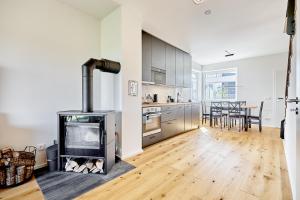 a living room with a fireplace and a kitchen with a table at Ore house by Mountain ways in Loučná pod Klínovcem