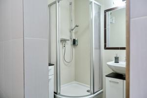 a white bathroom with a shower and a sink at Haus Nicola in Bad Gastein