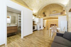 uma cozinha e sala de estar com um sofá e uma mesa em Scaringi Central Apartment em Trani