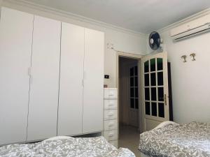 a bedroom with two beds and a large white cabinet at Spacious Beach Vacation House in El Alamein