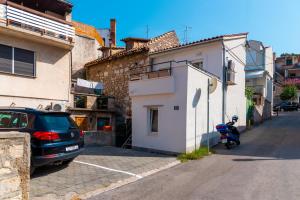 een auto geparkeerd op een parkeerplaats naast een gebouw bij CITY BREAK Studio apartments in Šibenik