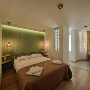 a bedroom with a large bed with two towels on it at River House Boutique Hotel in Yerevan