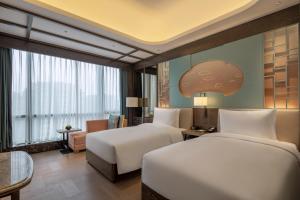 Habitación de hotel con 2 camas y sofá en CYNN XANADU Hotel Chengdu en Chengdú
