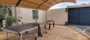 una mesa de ping pong dentro de un garaje en Maison dolce vita, en Ţūzah