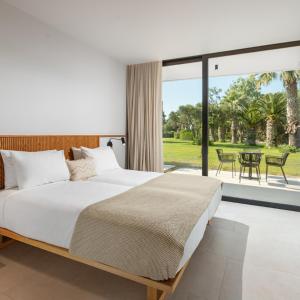 1 dormitorio con 1 cama grande y patio en Caravia Beach Hotel, en Marmari