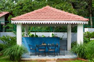 a gazebo with a table and chairs under it at Elivaas Bludoor Luxe 5BHK Villa with Pvt Pool, Assagao in Marmagao