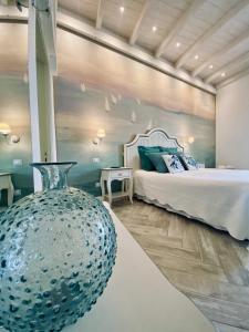 um quarto com uma cama e um vaso no primeiro plano em La Casa Di Ada E Gigi Vacanze em Porto Cesareo