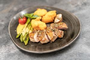 ein Teller mit Fleisch und Gemüse auf dem Tisch in der Unterkunft Der Ortnerhof - Hotel & Reiterhof in Prägraten