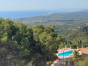 a villa with a swimming pool on a hill with trees at Villa roma in Benicàssim