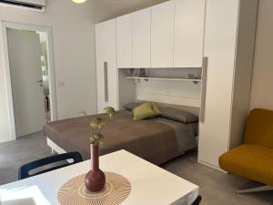 una habitación con una cama y una mesa con un jarrón. en Guesthouse Violetta DI Parma, en Parma