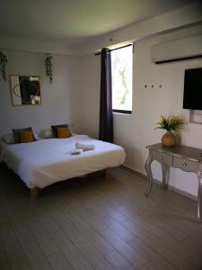 Q Village - Poleg Beach في نتانيا: غرفة نوم بسرير وطاولة ونافذة