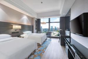 Cette chambre comprend 2 lits et une télévision à écran plat. dans l'établissement Renaissance Guiyang Hotel, à Guiyang