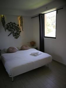 a bedroom with a white bed with two pillows on it at Q Village - Poleg Beach in Netanya