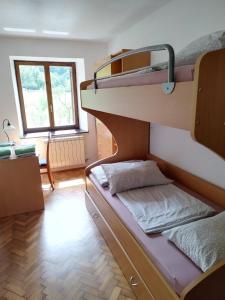 Ce lit superposé se trouve dans un dortoir doté d'une fenêtre. dans l'établissement Apartma Logar, à Kobarid