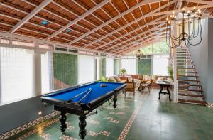 a pool table in a living room with a ceiling at Elivaas Bludoor Luxe 5BHK Villa with Pvt Pool, Assagao in Marmagao