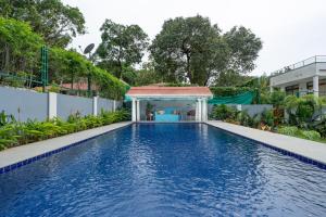 a swimming pool with a gazebo next to a building at Elivaas Bludoor Luxe 5BHK Villa with Pvt Pool, Assagao in Marmagao