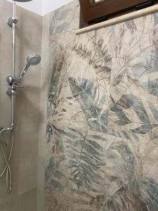 a shower in a bathroom with a mural of plants at Medusa Apartment in Tropea +10 photos