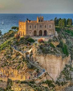 un grande edificio in cima a una scogliera vicino all'oceano di Medusa Apartment a Tropea