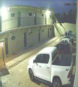 a white truck parked in front of a building at LOCANDA DA SERRA - Aptos Mobiliados por Temporada in Barra do Garças
