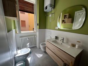 a bathroom with a sink and a toilet and a mirror at VIOLETTA DI PARMA in Parma
