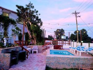 a backyard with a pool and chairs and a table at Queensburgh B&B or Self Catering in Durban