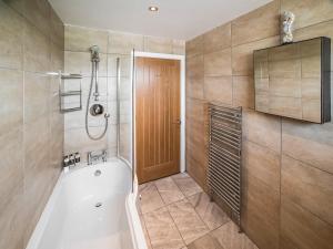 a bathroom with a bath tub and a shower at Two Seas Hebrides in Eoropie
