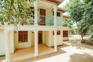 ein Haus mit einer Veranda und Säulen in der Unterkunft Bamboo Village in Arusha