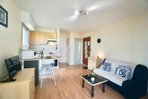a living room with a couch and a kitchen at La Guérite*front de mer*parking* in Ploemeur