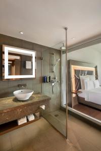 een badkamer met een wastafel en een bed bij Novotel New Delhi Aerocity- International Airport in New Delhi
