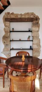 een tafel en stoelen in een kamer met een stenen muur bij Duplex Dax in Dax