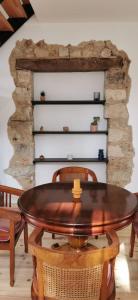 a table and chairs in a room with a stone wall at Duplex Dax in Dax
