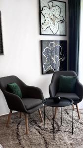 a living room with two chairs and a table at Studio Apartman Lucija in Osijek