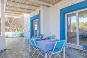 una sala da pranzo con tavolo e sedie blu di Villa B. Calaliberotto a Cala Liberotto