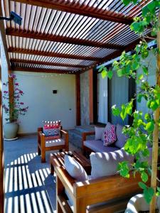 a patio with a couch and chairs and a wooden pergola at Luxury Villa With a Pool in Soma Bay in Hurghada