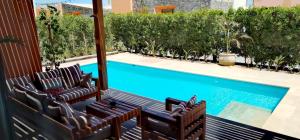 un patio con 2 sillas y una piscina en Luxury Villa With a Pool in Soma Bay, en Hurghada