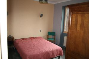 1 dormitorio con 1 cama y 1 silla verde en HAVRE DE PAIX A LOUBEYRAT EN AUVERGNE, en Loubeyrat