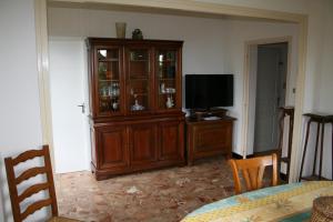 sala de estar con TV y armario de madera en HAVRE DE PAIX A LOUBEYRAT EN AUVERGNE, en Loubeyrat