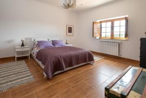 een slaapkamer met een bed en een houten vloer bij Quinta da Palhota in Vila de Rei