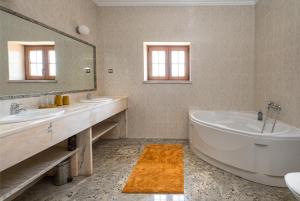 a bathroom with two sinks and a tub and a mirror at Quinta da Palhota in Vila de Rei +11 photos
