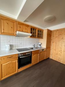 a kitchen with wooden cabinets and a sink at Ferienwohnung 121a - Top 2-3 in Königsleiten