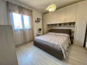 um quarto com uma cama grande e uma janela em Trilocale Sul Lungomare em Cannigione