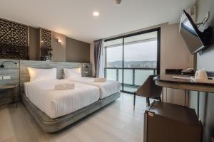 um quarto de hotel com uma cama e uma grande janela em วัน บัดเจท เชียงราย เชียงแสน One Budget Chiangrai Chiangsaen em Ban Lan Dok Mai